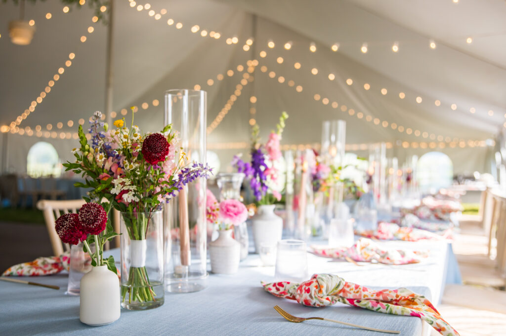 Smaller bottle vases with layered colorful blooms on reception tables