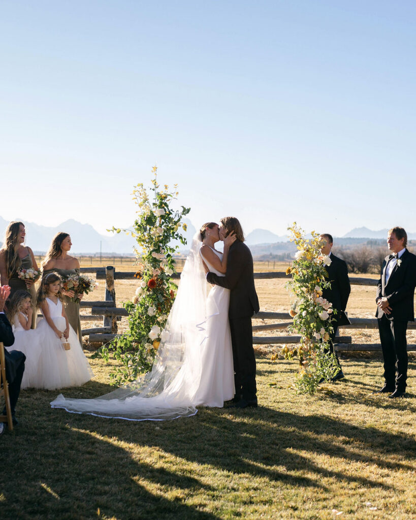 Fall wedding ceremony with bride and groom in front of Tetons at Diamond Cross Ranch wedding venue in Jackson WY - Dandelion Floral - wedding florist
